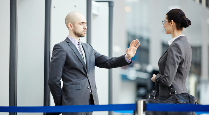 commercial security guard stopping a woman before entering a building